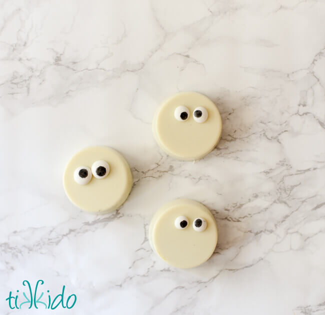 Chocolate covered oreos decorated with edible googly eyes for a Halloween party.