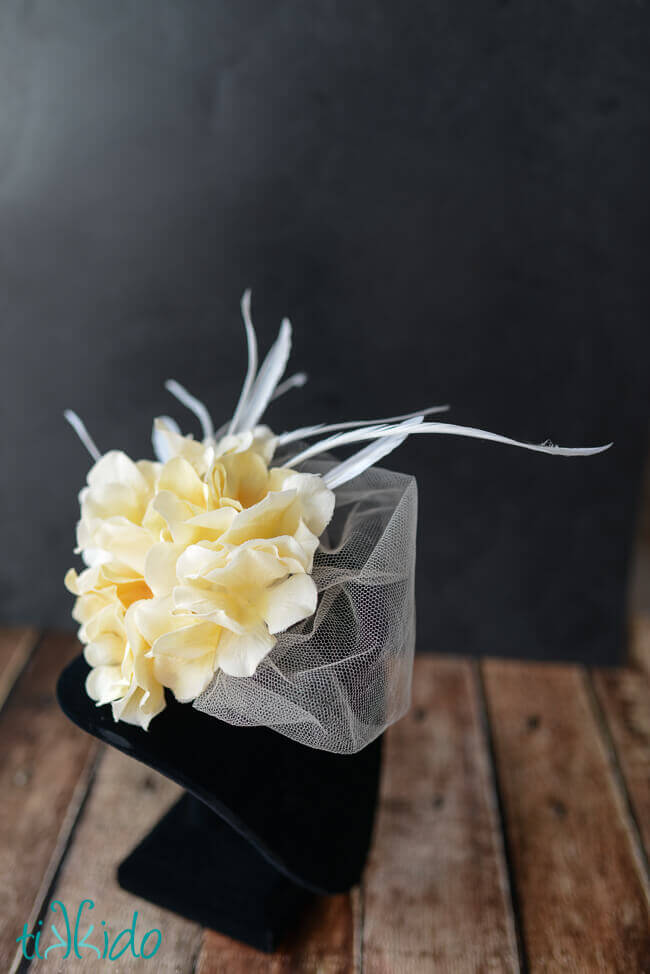 DIY fascinator with veiling, feathers, and silk flowers.