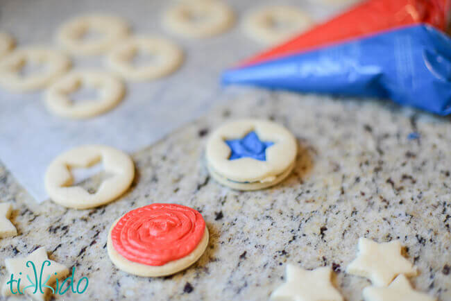 Patriotic sandwich sugar cookies filled with red and blue buttercream and pop rocks candies.