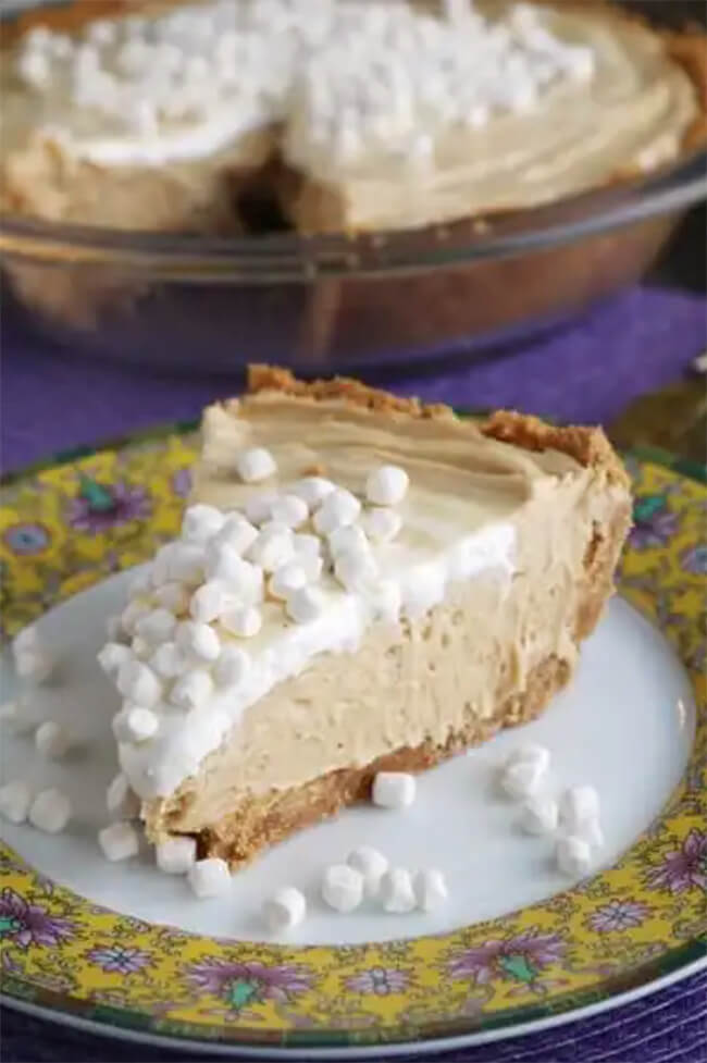 Slice of fluffernutter pie topped with mini marshmallows sitting on a floral plate.