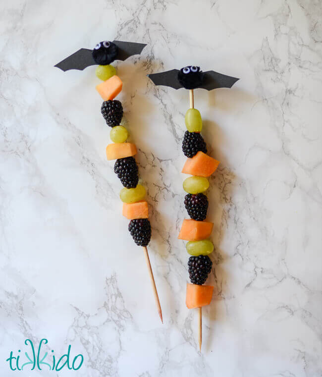 Healthy Halloween fruit skewer topped with a cute little bat.