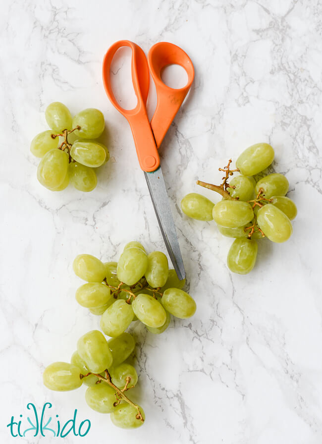 Green grapes cut into small clusters to make a Christmas wreath shaped Christmas Fruit Tray.