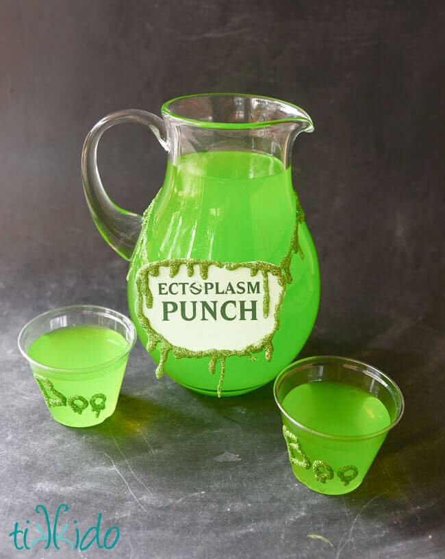 Glitter slime garland decorating a glass pitcher filled with green Ectoplasm Punch.