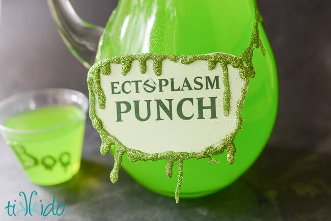 Glitter slime garland decorating green ectoplasm punch in a glass pitcher.