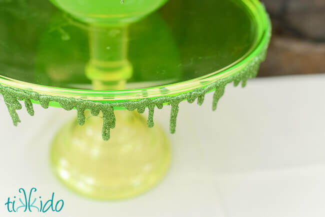 Glitter slime garland decorating a green vaseline glass cake plate.