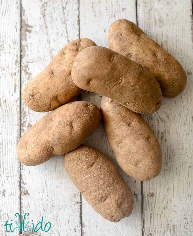 Potatoes on a weathered white wooden background.