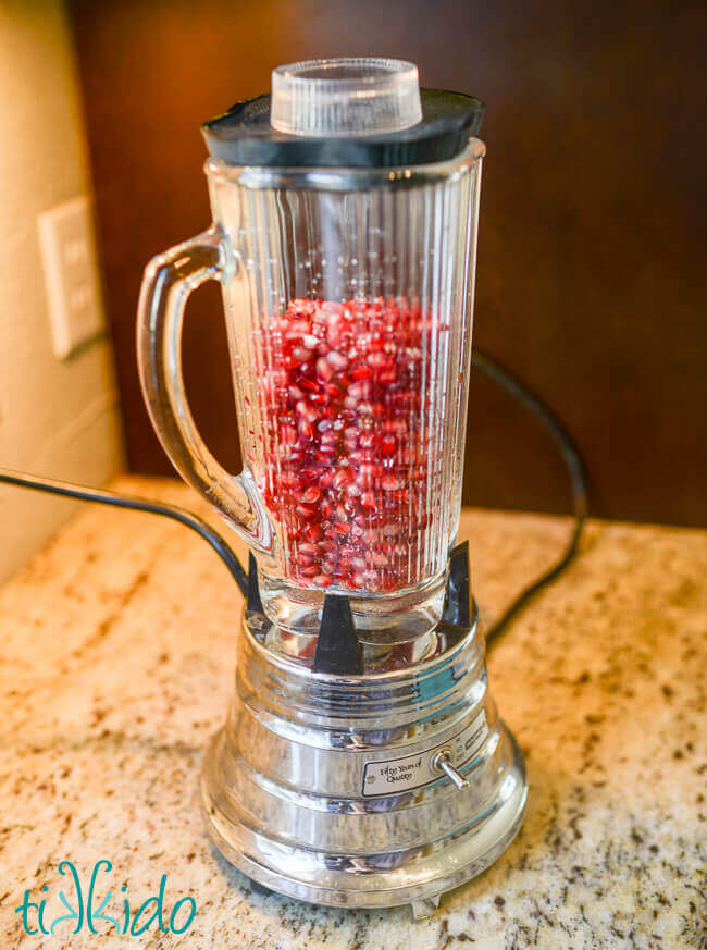 Pomegranate seeds in a blender to make pomegranate juice for homemade grenadine.