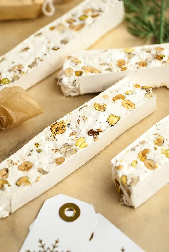 Slices of torrone Italian Christmas candy on brown kraft paper.