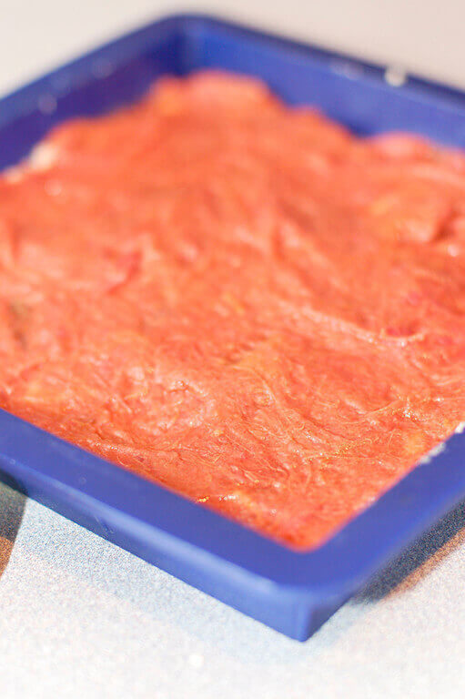 Cookie dough topped with rhubarb in silicone pan