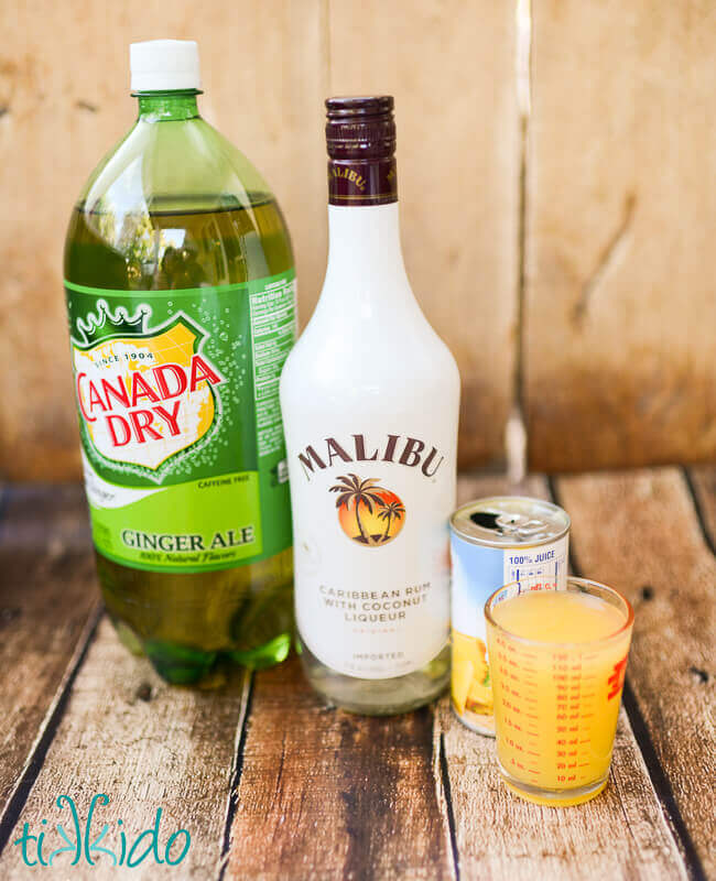 ginger ale, Malibu coconut rum, and pineapple displayed on a warm brown wooden backdrop