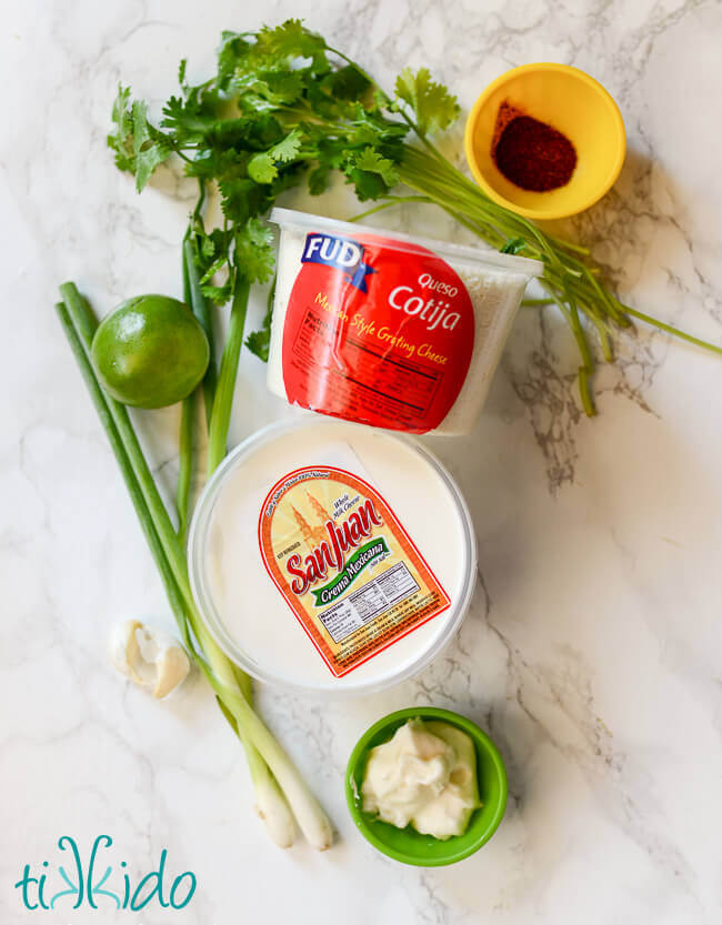 Ingredients for Mexican Street Corn Salad on a white marble background.