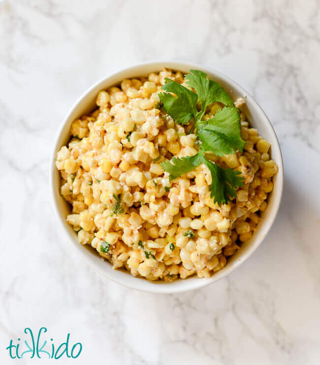 Mexican Street Corn Salad in a white bowl on a white marble background