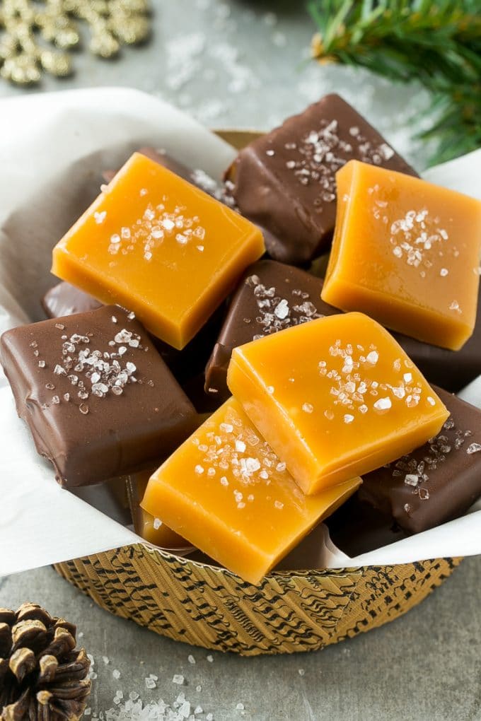 Bowl of microwave caramels and chocolate covered caramels topped with sea salt.