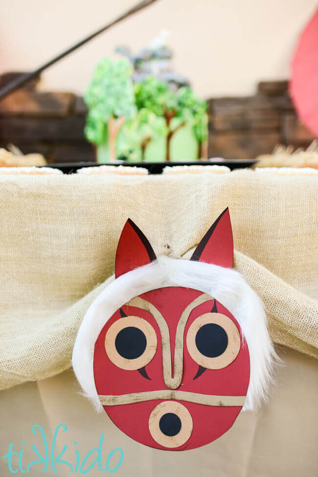 Paper princess Mononoke mask used as birthday party decor.