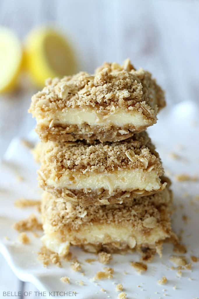 Three oatmeal lemon creme bars stacked on a white plate.