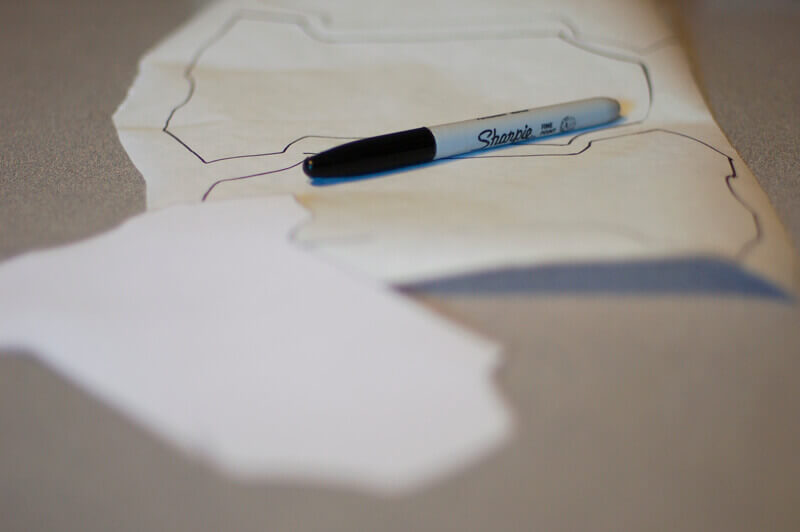 Onesie template being used to trace the shape on freezer paper for the Baby Shower Garland