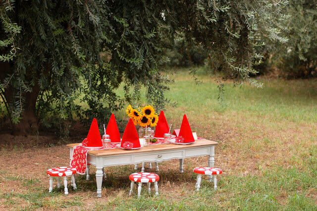 Gnome hats sitting on a low table surrounded by stools painted like toadstools.