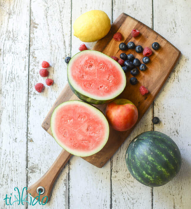 Ingredients for 4th of July Fruit Salad on a wooden cutting board.