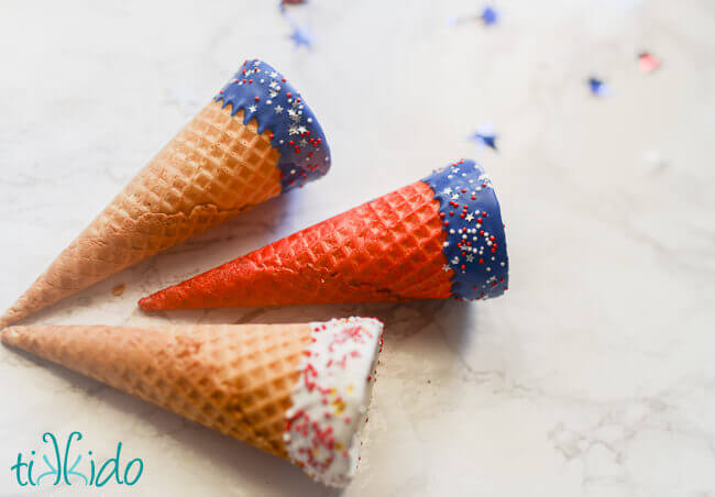 Red, white, and blue ice cream cones with chocolate and sprinkles.