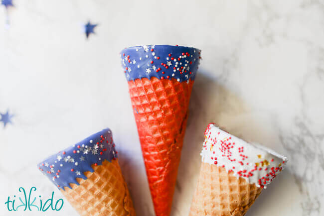 Red, white, and blue ice cream cones with chocolate and sprinkles.