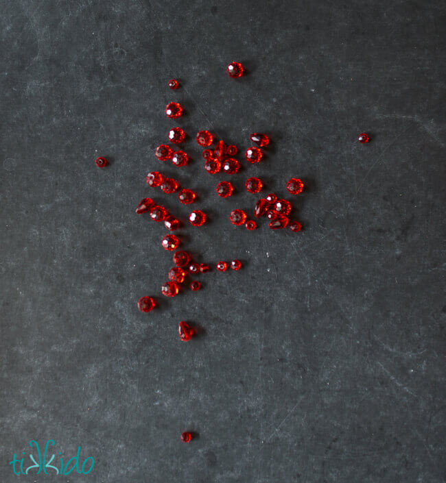Red crystal beads on a black chalkboard background.