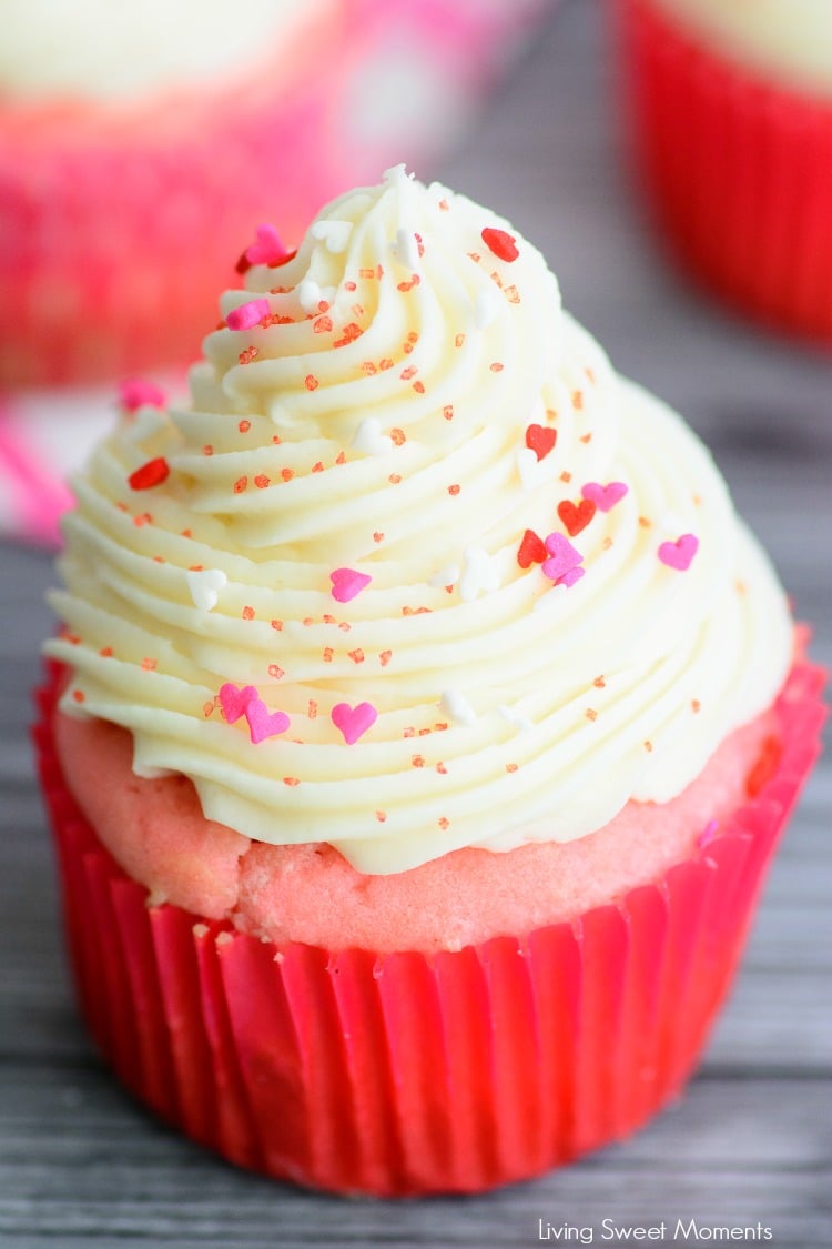 Pink velvet cupcake with cream cheese icing and heart sprinkles.