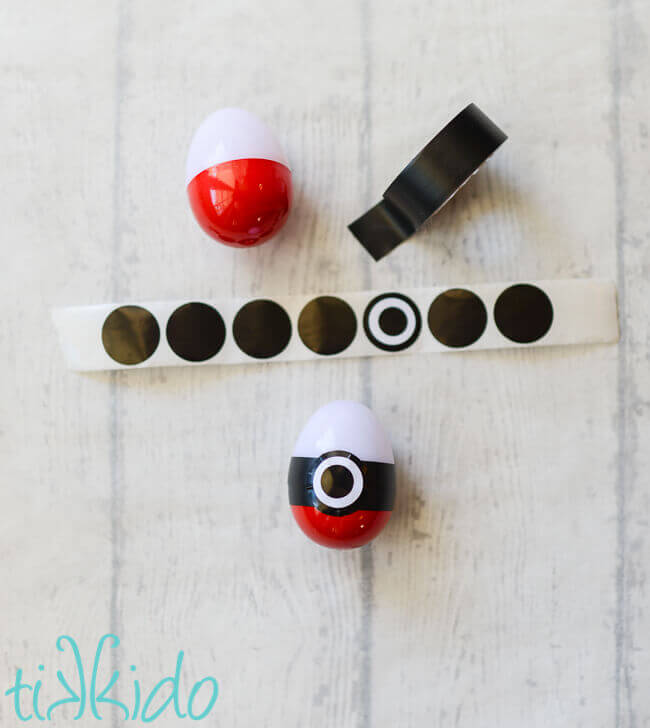 Decorating the pokemon easter eggs with black and white round stickers and electrical tape.