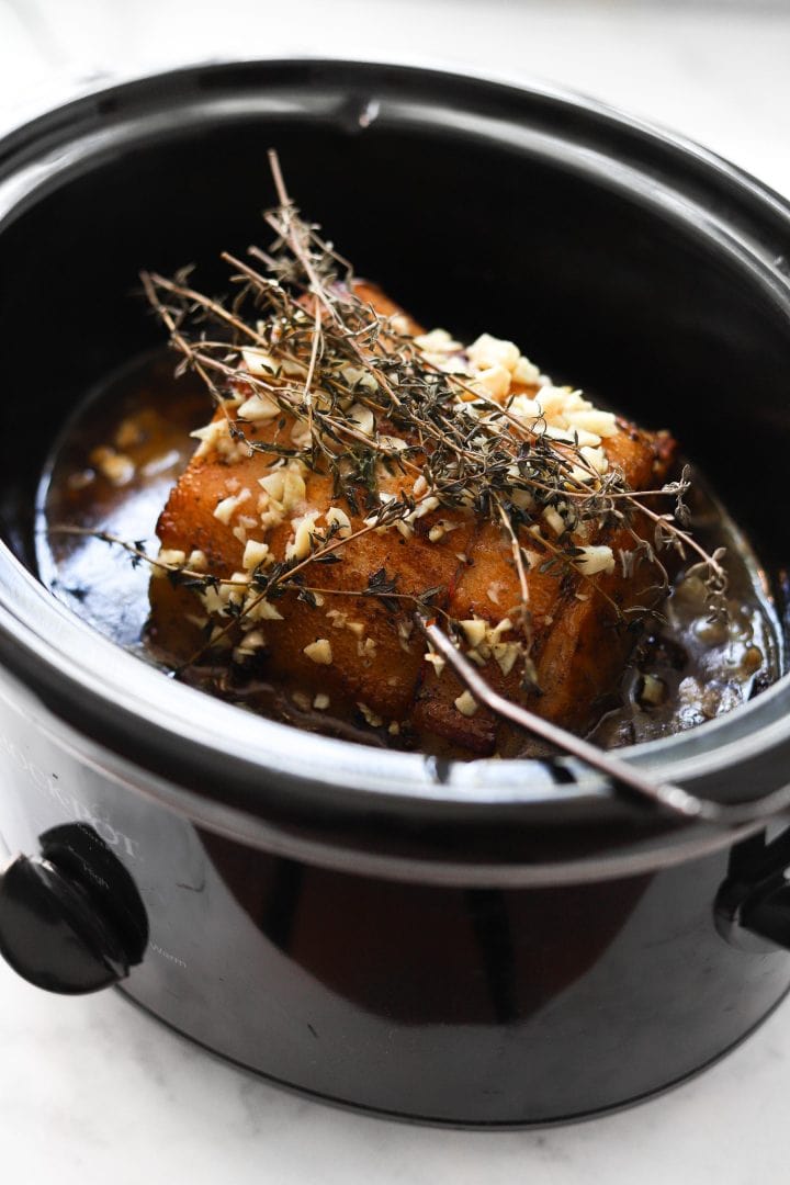 Crockpot pork loin being made in a slow cooker.