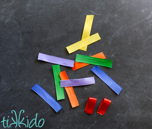 Satin ribbon in rainbow colors cut into small pieces for the rainbow ribbon flower on the DIY headband.