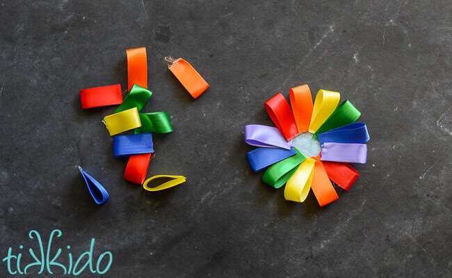 Loops of rainbow colored ribbon being glued in a circle for the rainbow headband.