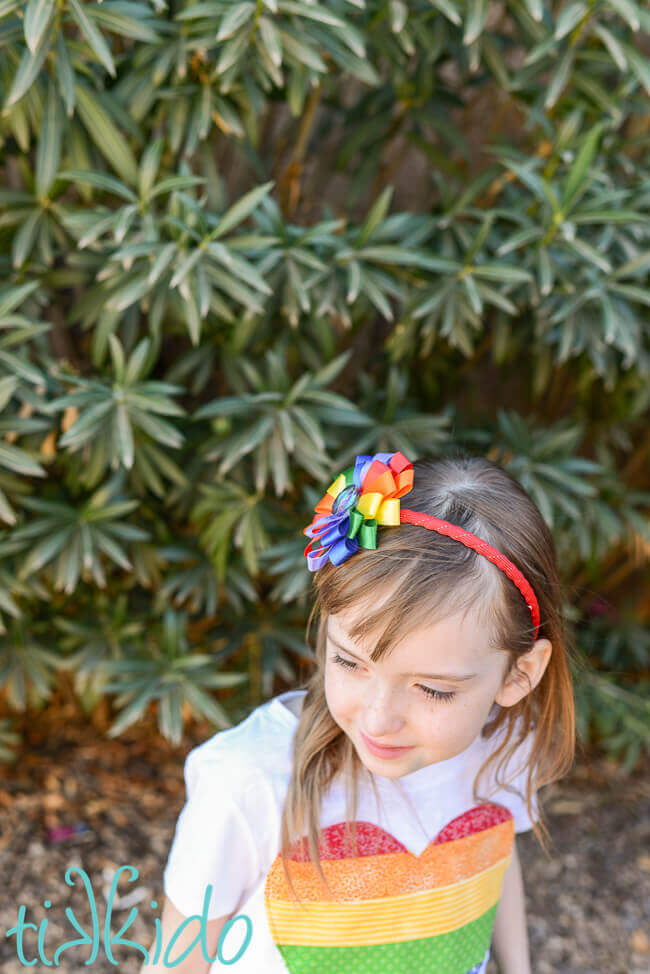 Little girl wearing a DIY Rainbow ribbon flower headband.