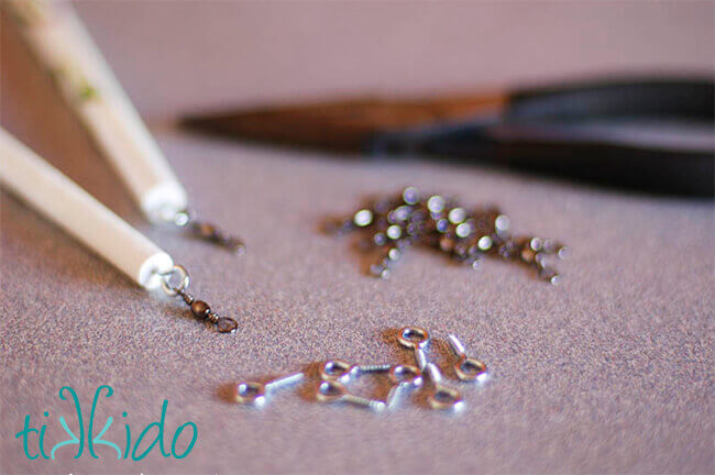 Fishing swivels being attached to the end of a wooden dowel to make a ribbon wand.