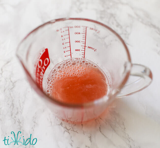 strained rhubarb juice in a pyrex measuring cup