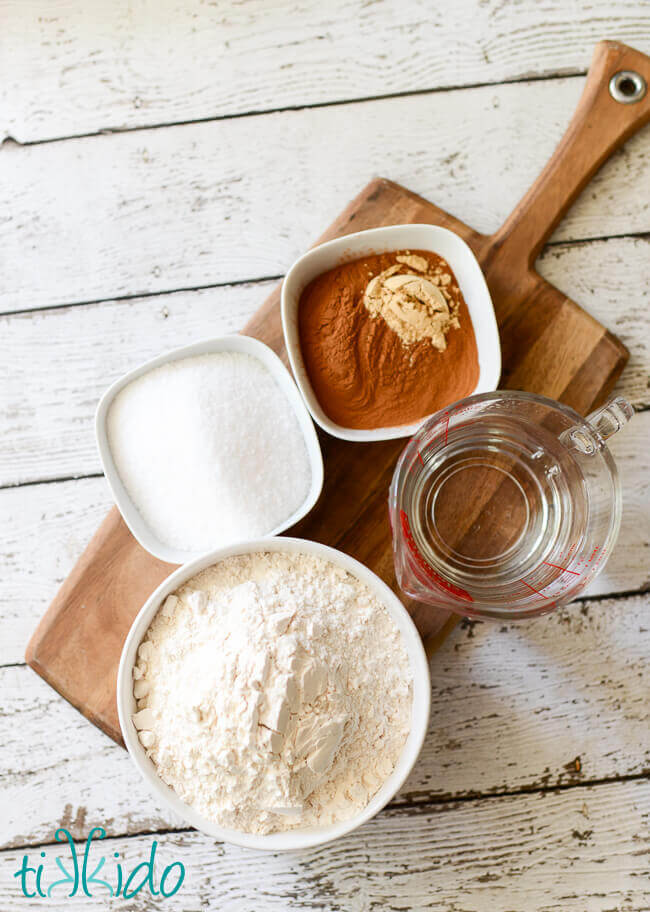 Ingredients for gingerbread salt dough ornaments recipe on a wooden cutting board.