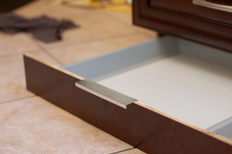 Kitchen cabinets with hidden toe kick drawer