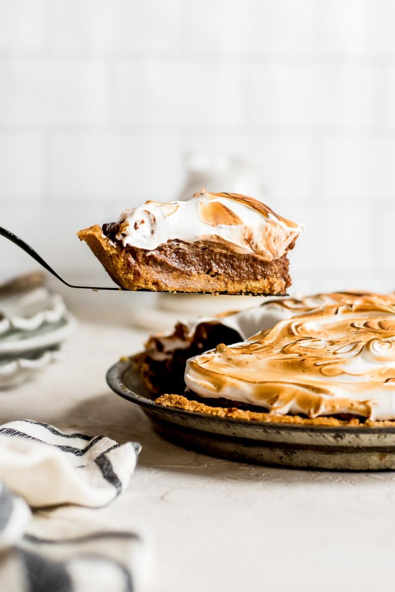 Slice of S'mores pie being lifted out of a pie tin with the rest of the pie.