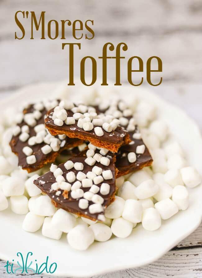 Pieces of S'mores toffee candy on a white plate covered with miniature marshmallows.