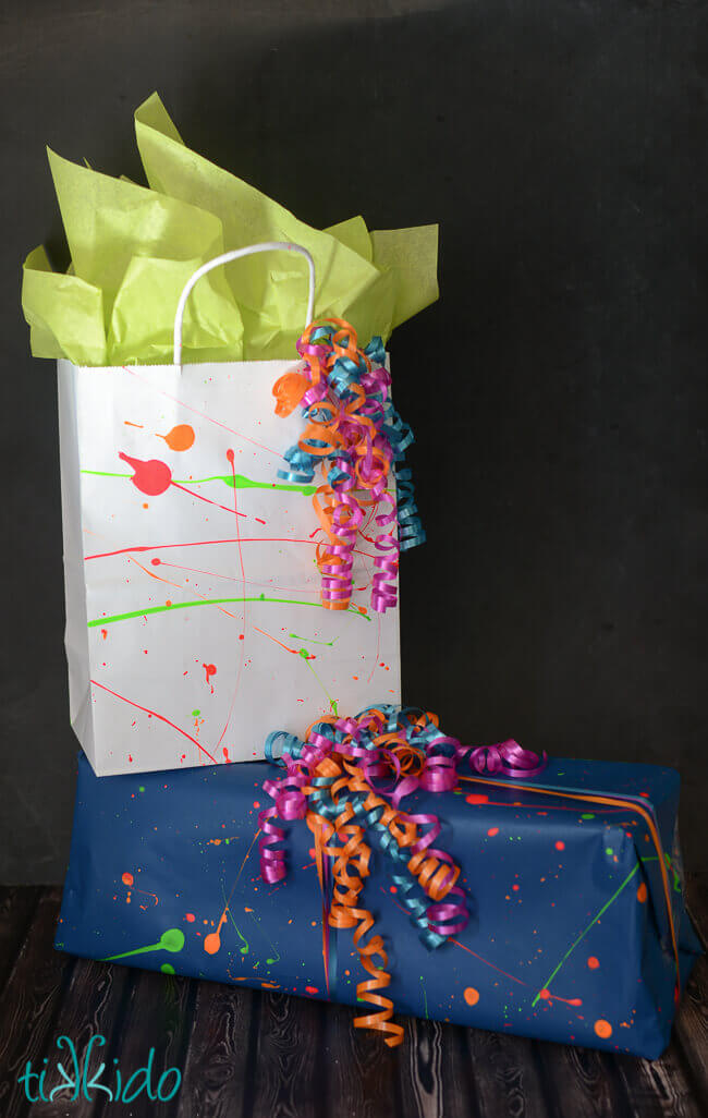 Gifts wrapped with Splatter Paint Wrapping Paper on a dark background.