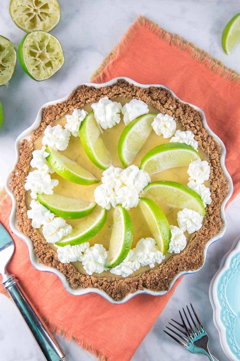 Margarita pie with salted graham cracker crust in a white pie dish on an orange placemat.