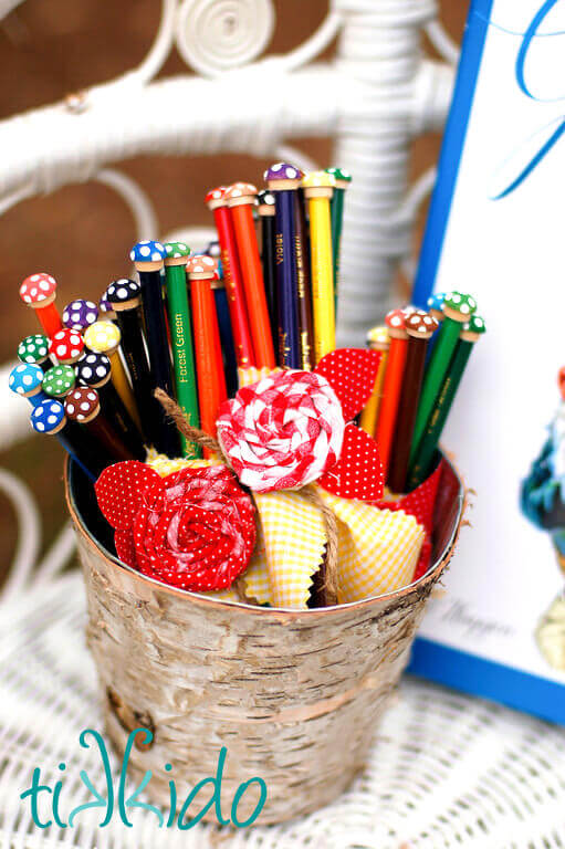 Twisted fabric roses decorating colored pencil favors at a Gnome birthday party.