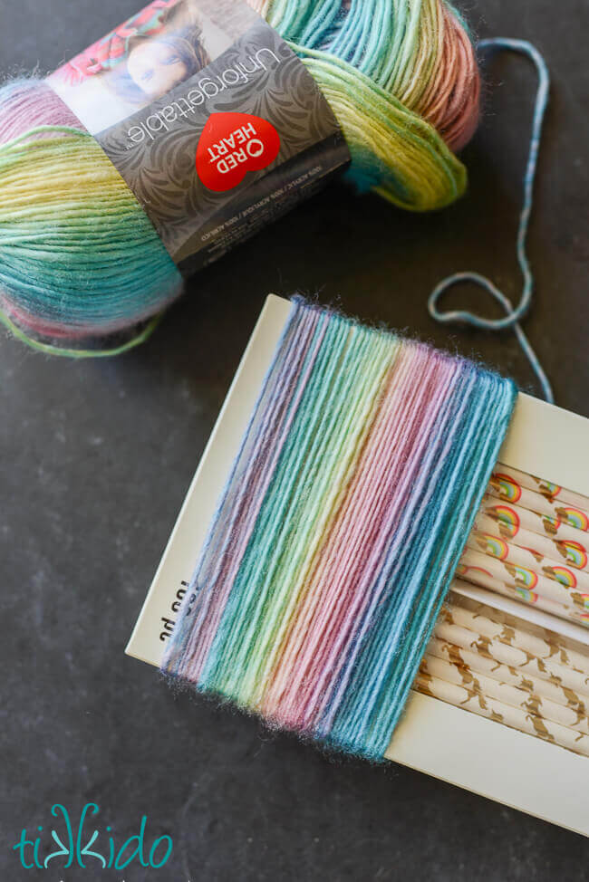 Pastel rainbow yarn for yarn tassel unicorn tails wrapped around a box.
