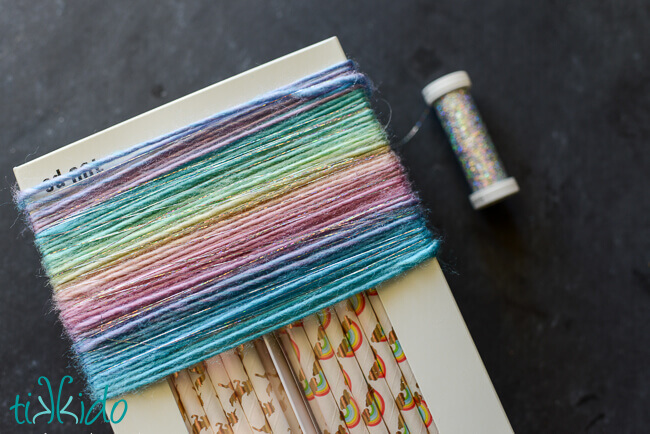 Pastel rainbow yarn for yarn tassel unicorn tails wrapped around a box.