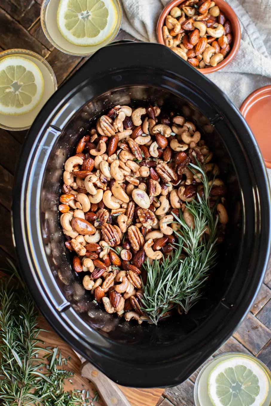 Crockpot filled with mixed nuts and fresh rosemary, to make Union Square Bar Nuts.
