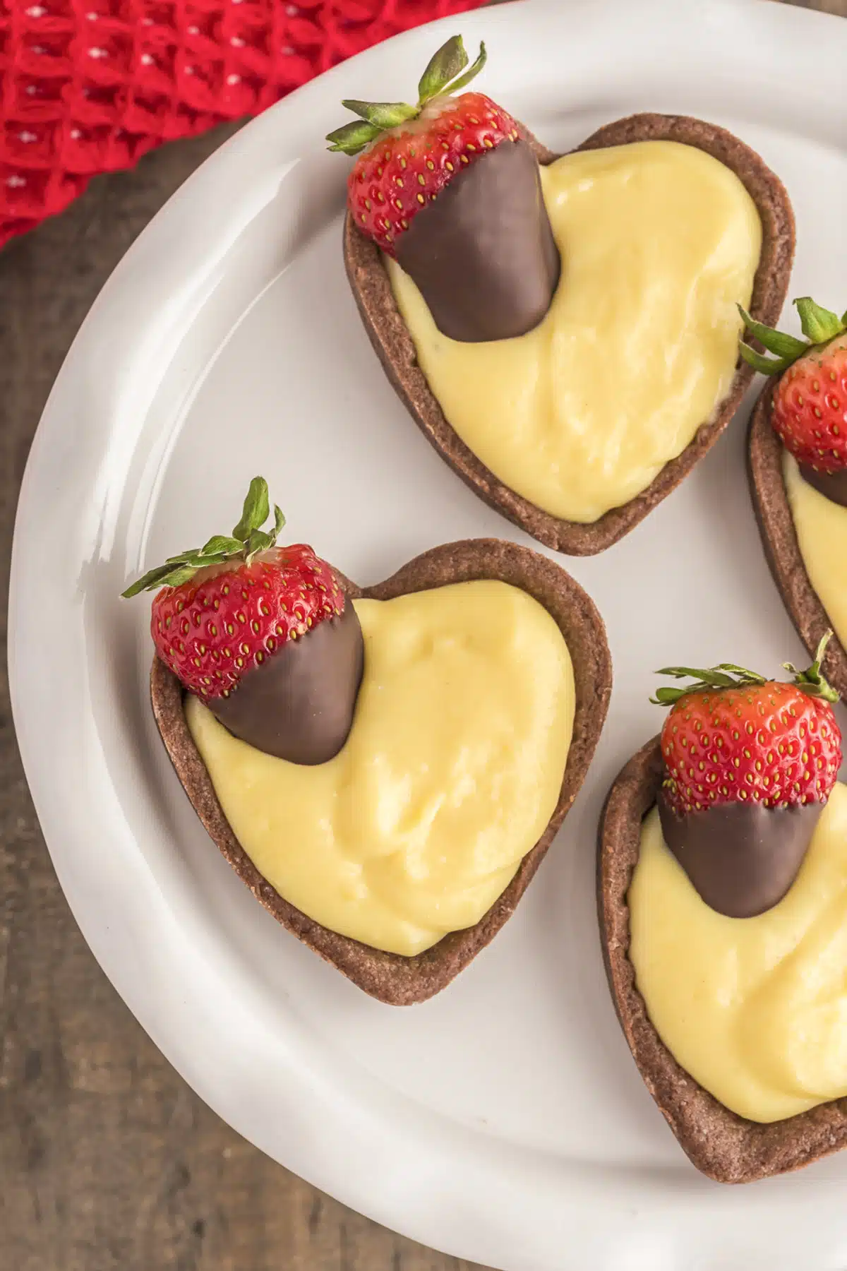 Chocolate covered strawberry Italian valentine's day tarts on a white plate.