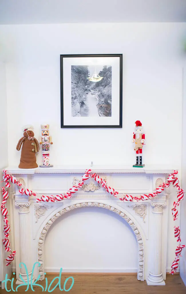 Advent calendar garland that looks like giant peppermint candies on a white fireplace mantel.