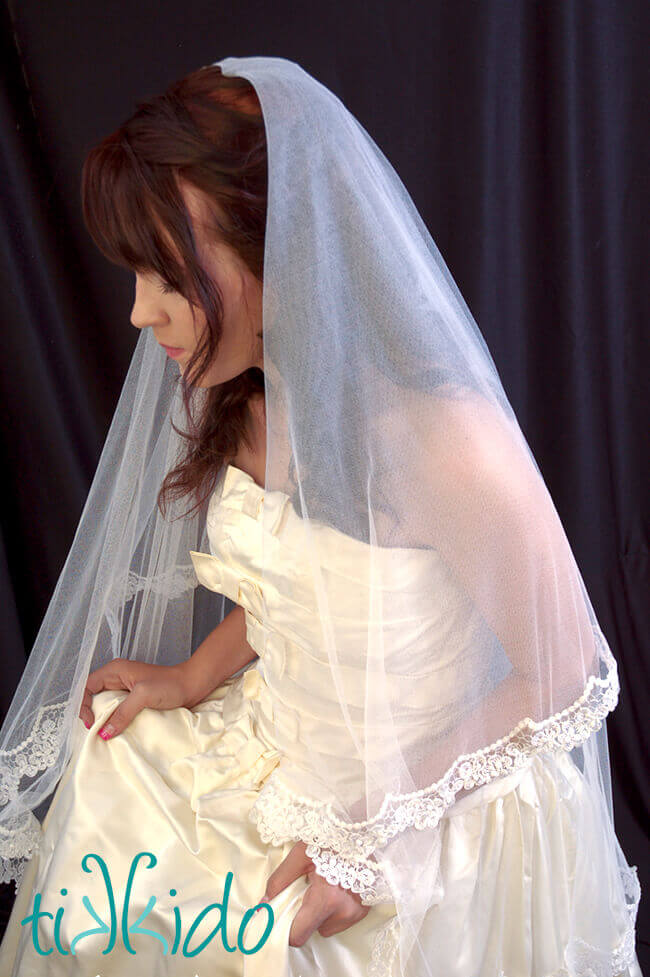 woman wearing a center gathered silk tulle wedding veil.