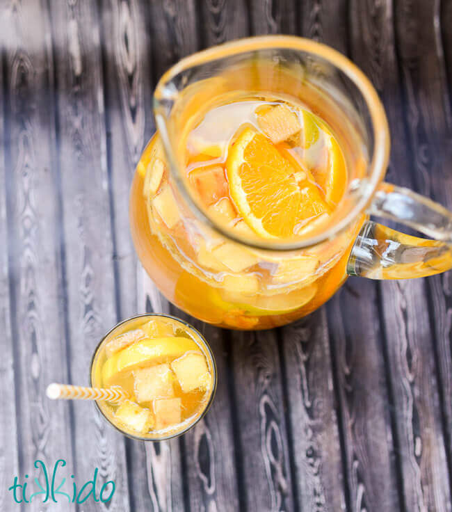 Pitcher of White Sangria on a wooden backdrop.