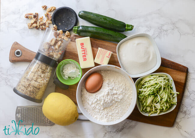 Zucchini cookie recipe ingredients on a wooden cutting board.