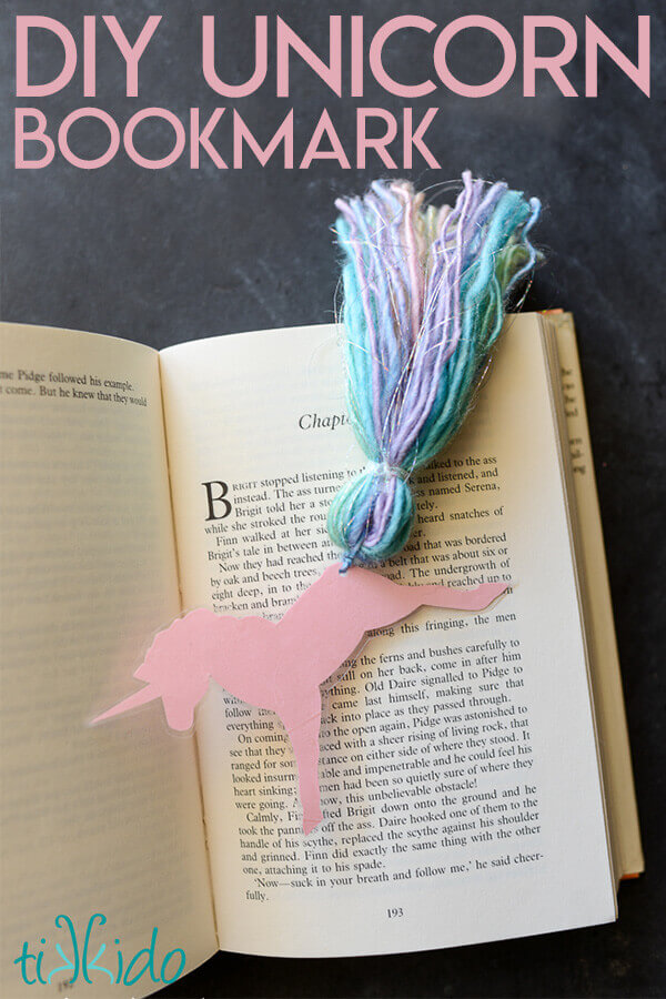 Unicorn bookmark that looks like a running unicorn with a rainbow tassel tail on an open book.